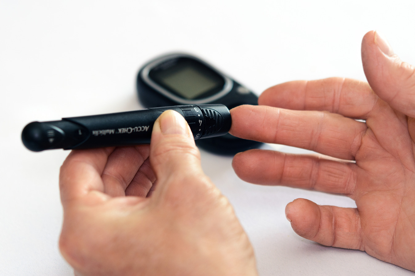 Patient checking blood sugar levels with an at-home machine